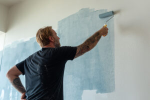 Man painting wall blue